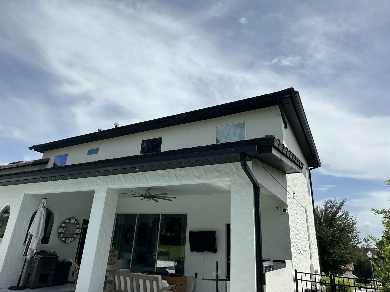 Clay tile roof in Central Florida with a black seamless gutter installed under the tile overhang by Gutters C2U.