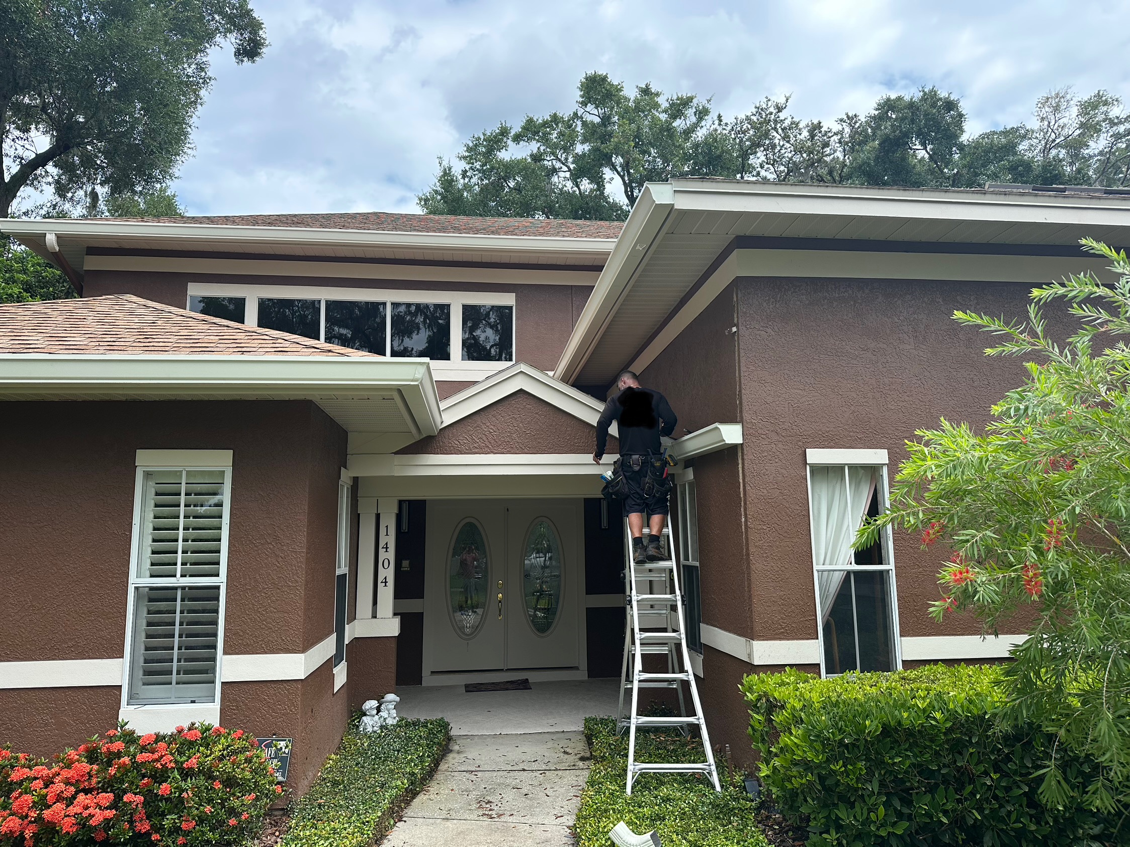 Gutters C2U installer on a ladder installing gutter guards at a home in Winter Park, FL