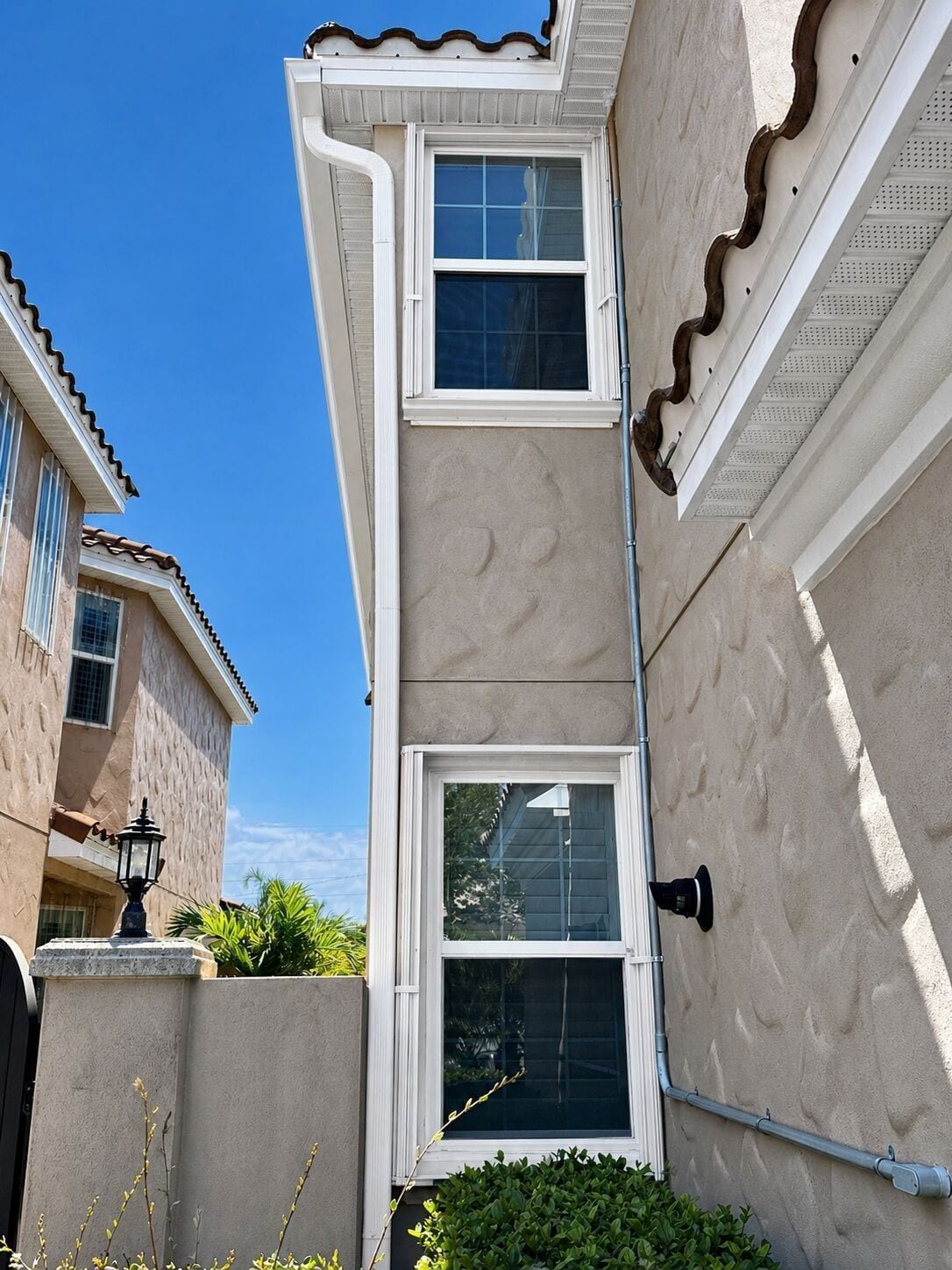 Downspout running down a two-story stucco wall in Central Florida
