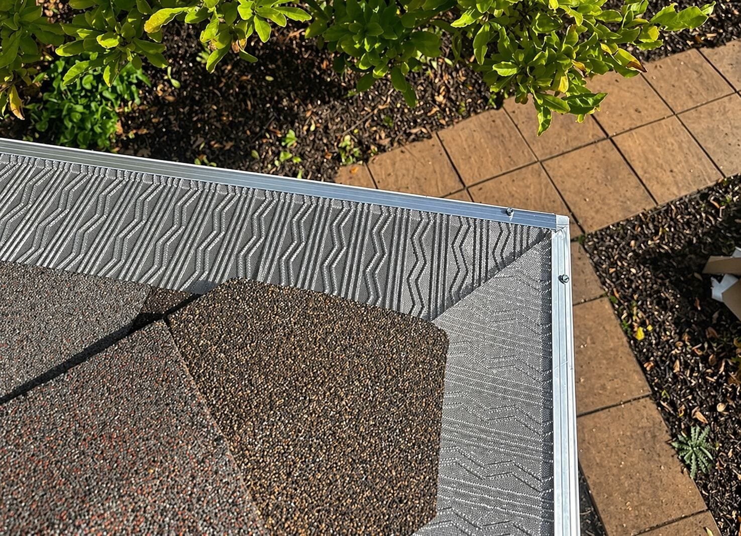 Gutter guard installed along a roof edge, seen from above