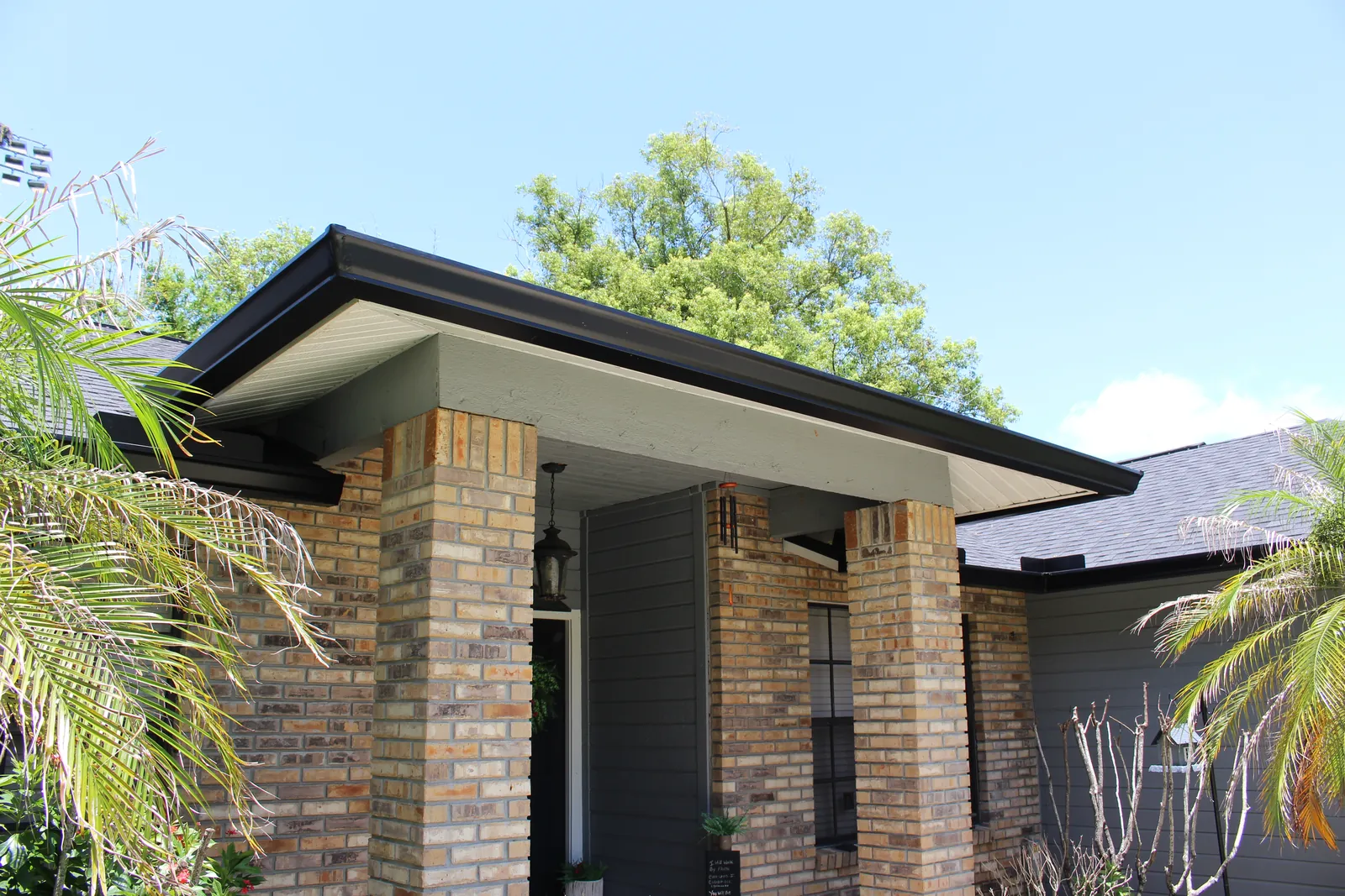 Dark bronze seamless gutters on a brick and siding home in Longwood, FL