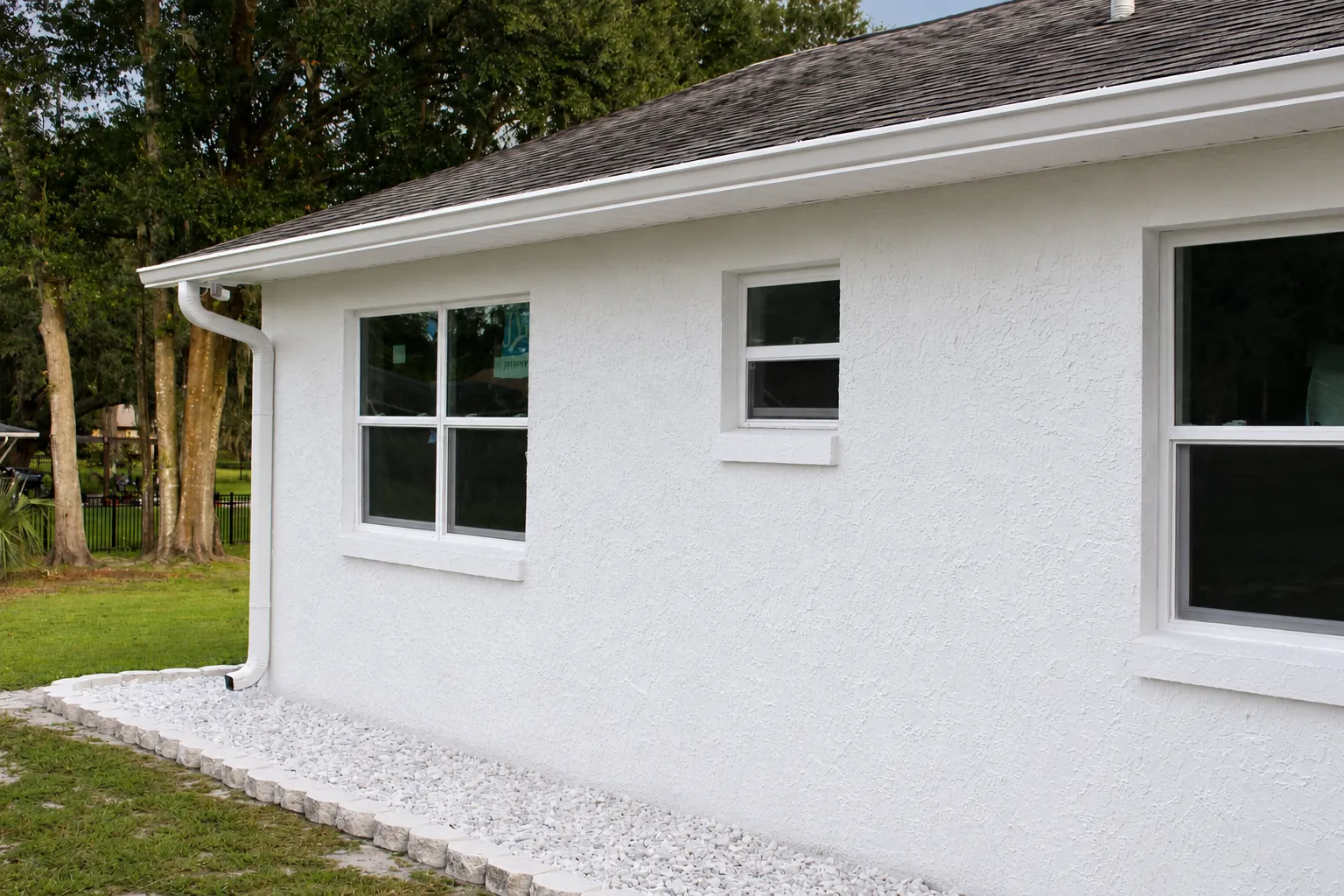 White gutters and downspout over a gravel bed in Oviedo, FL